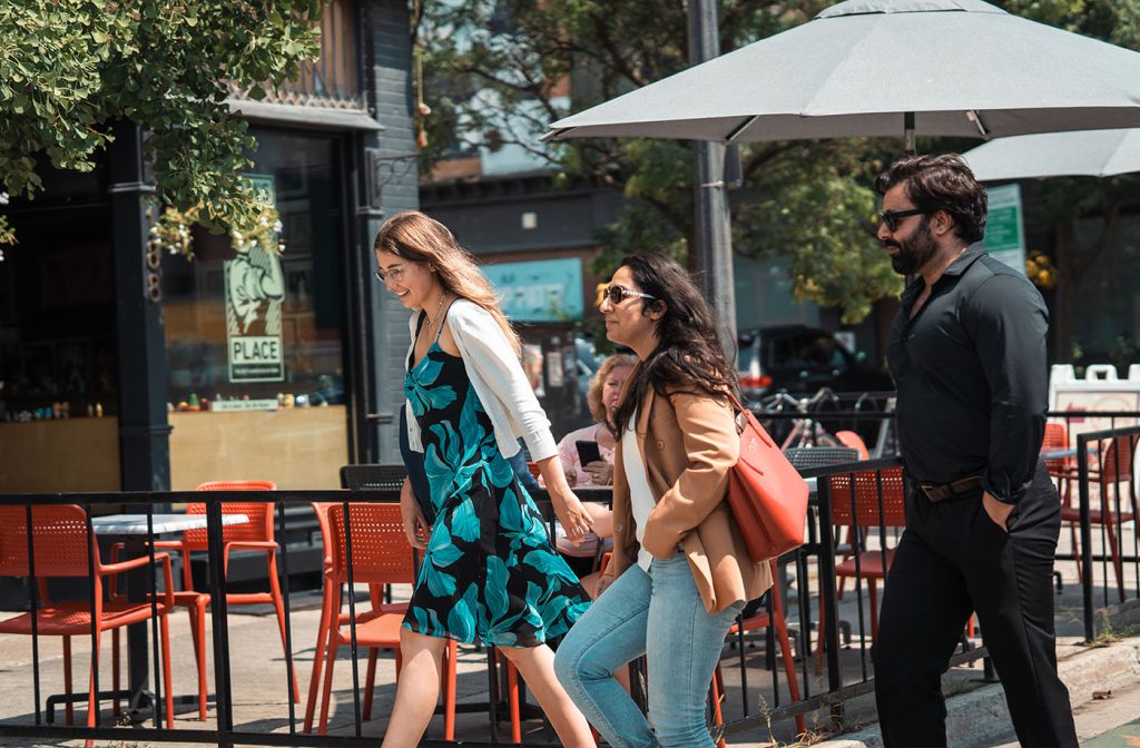 A guided walking tour passing patios in downtown Peterborough